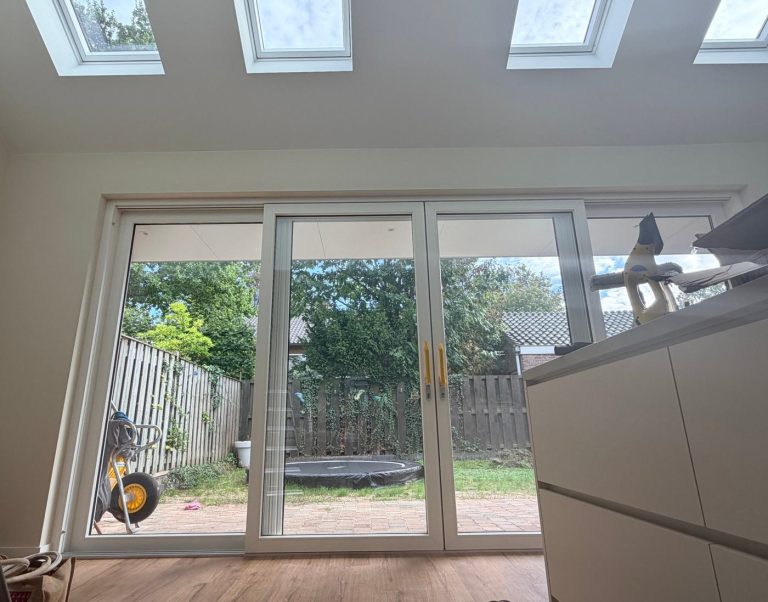 Leefkeuken met vier Velux-dakramen en schuifpui naar de tuin
